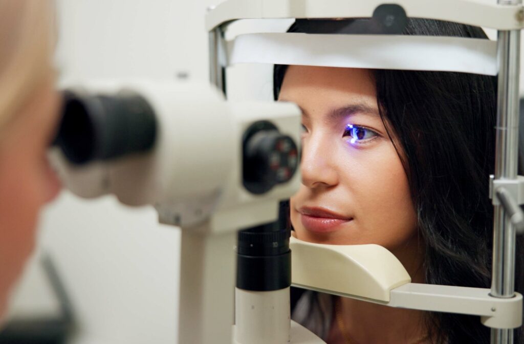 An adult gets their eyes examined by an optometrist.