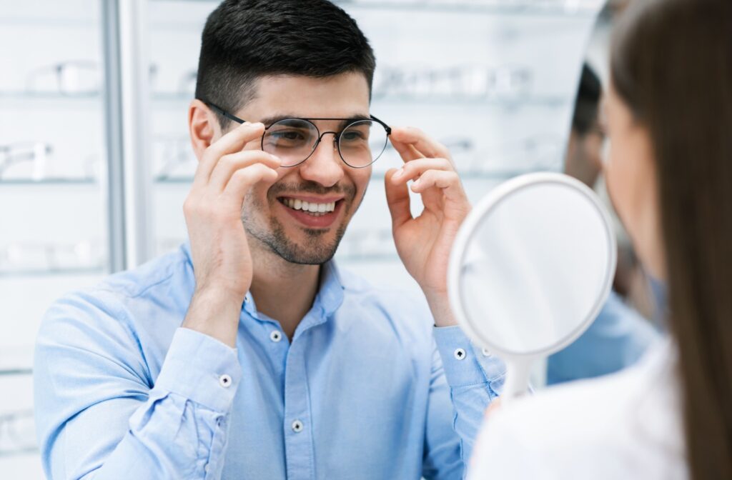 Man at the eye doctor trying on a pair of slim black eye glass frames